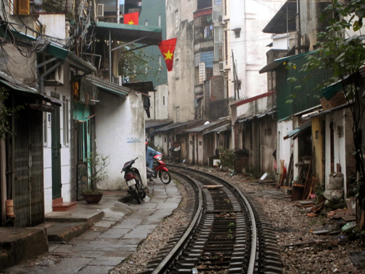 Vía de tren por medio de una calle de Hanoi, Vietnam.